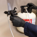 Technician holding 3M Water-Based Spray Adhesive Gun attached to Fastbond 1049 cylinder during setup.