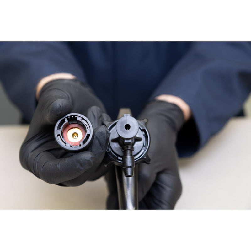 Technician preparing to attach 3M Water-Based Spray Nozzle to cylinder applicator gun.