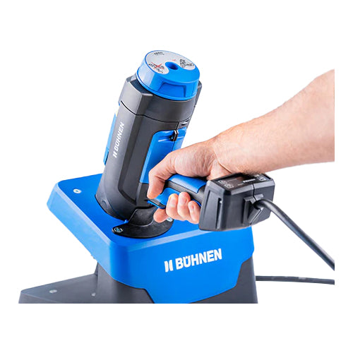 Hand placing Buehnen HB 720 hot melt applicator into blue tool stand with air service unit for storage and stability