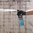 Spraying DAP Weldwood Landau Top & Trim Contact Adhesive in wide fan pattern against concrete wall background