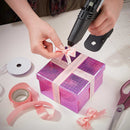 Tec 305 hot glue gun applying adhesive to ribbon on gift box for crafting and decorative DIY projects