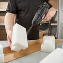 Tec 6300 spray glue gun applying hot melt adhesive to multiple foam packaging pieces during assembly.