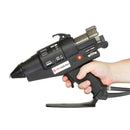 The Power Adhesives Tec 6100 pneumatic glue gun is shown held in one hand, highlighting the trigger, grip, and attached air hose.